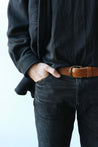 Ledergürtel für Herren in Braun getragen in einer schwarzen Jeans.