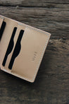 Detailansicht eines Kartenfachs von einem Leder Kartenetui in Natural auf einer Holzplatte.