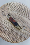 Ein Leder Schlüsselanhänger in Camouflage mit einem Karabiner und Schlüsselring in Messing Antik auf einem Holzstuhl.
